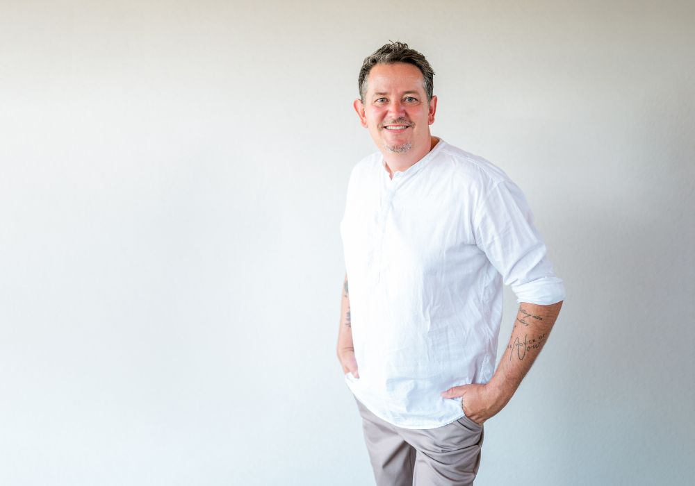 Maler Markus Winkler-Dick vor einer frisch gestrichenen Fassade in Feldbach in der Steiermark.